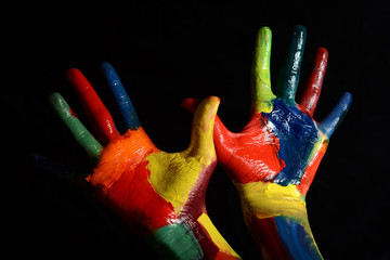 Colorful hands painted with oil paint on black background