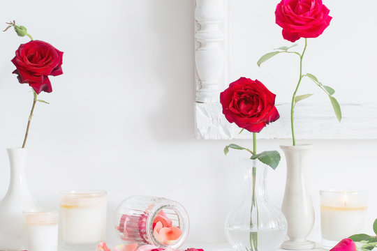 roses in a vase and candles on white background