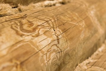 Roundish brown wooden logs with insulation, background