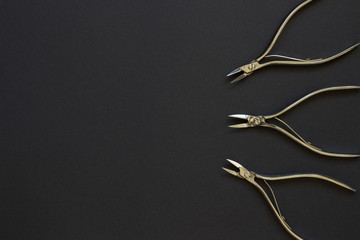 Manicure and pedicure cuticle nippers on the dark background