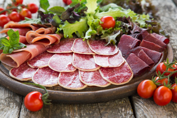 Antipasto with ham, salami and bresaola. tomato and basil. selec
