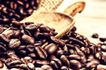 Roasted coffee beans with old wooden scoop