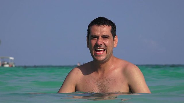 Happy Man Waving And Swimming In Ocean