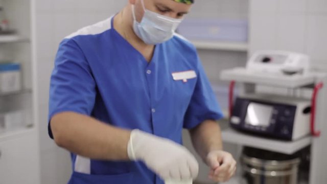Doctor putting on medical glove in operating room