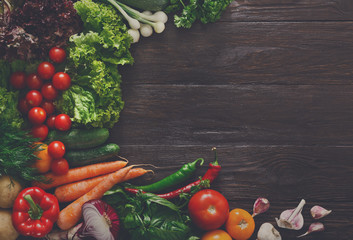 Border of fresh vegetables on wooden background with copy space