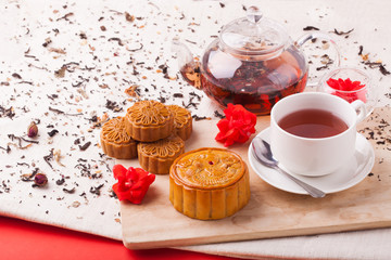 Chinese mid autumn festival foods. Traditional mooncakes on table setting with teacup.