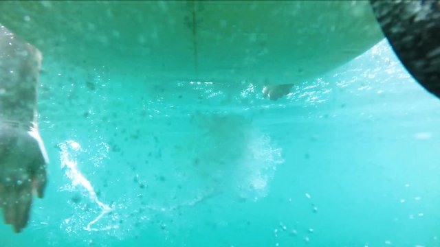 Slow Motion Aufnahmen von Surfer mit Surfboard im Wasser