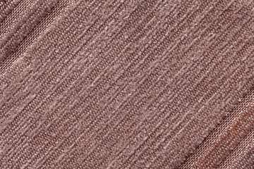 Light brown background of a knitted textile material. Fabric with a striped texture closeup.
