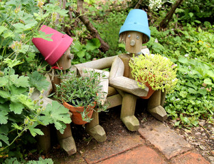 Two Wooden Flower Pot Holders in a Garden.