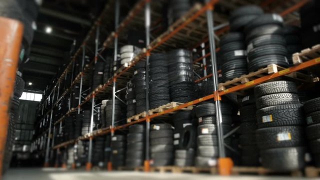 Car Tires At Warehouse In Tire Store. A Huge Warehouse of a Car Tires Stored On Shelves