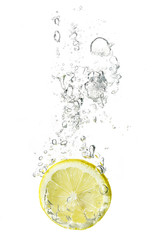 Fototapeta na wymiar lemon slice dropped into water with bubbles