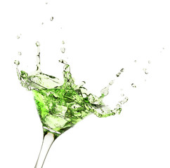 green liquid splashing in martini glass isolated on white