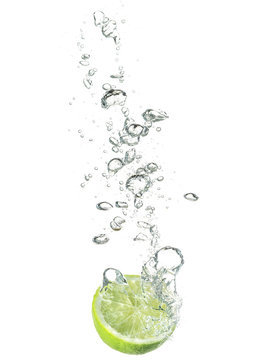 lime dropped in water isolated on white