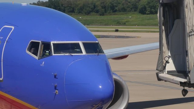 The jetway moves into place to let passengers disembark from an airplane.	