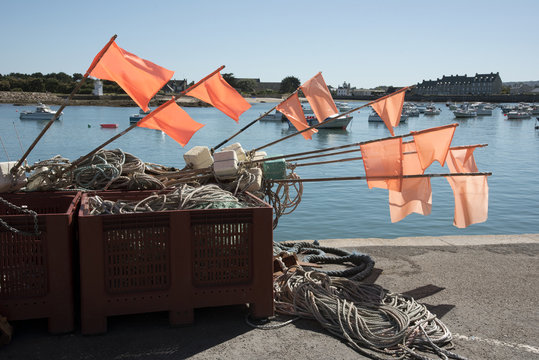 The coastal commune of Barfleur in Normandy northwest France. Fisherman's marker flags on the quay