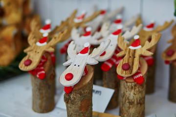 Funny wooden moose deers with red noses and Santa hats