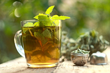 A cup of melissa tea on wooden background
