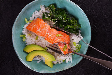 Salmon with spinach and avocado. Rice as a garnish. View from above, top studio shot