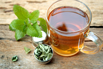 A cup of melissa tea on wooden background
