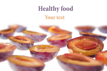 Slices of ripe plums isolated on white background. Decorative frame. Food background.
