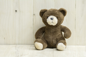 Brown teddy bear on wooden floor