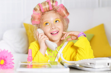 little girl in hair curlers and phone