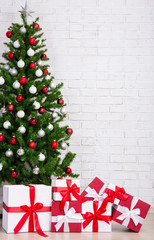 Gift boxes and decorated christmas tree with colorful balls over