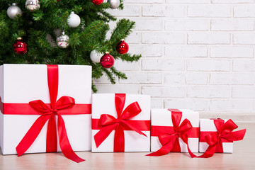 close up of gift boxes under decorated christmas tree