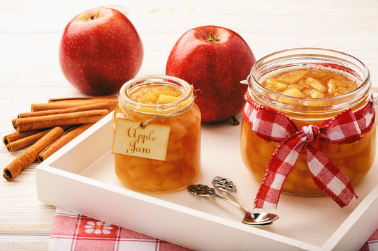Apple jam in glass jars on white background.