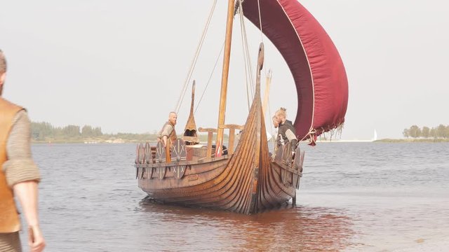 Mad vikings on the Drakkar on the river shore
