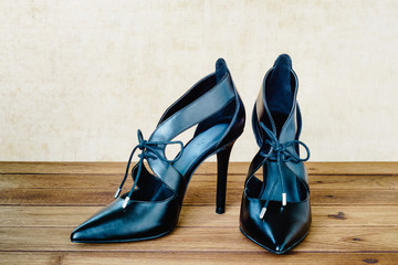 Black high heel shoes on wooden background