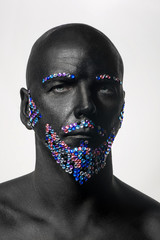 Man painted in black color with rhinestones hair, beard and eyebrows