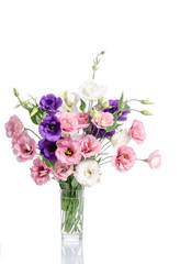 bunch of violet, white and pink eustoma flowers in glass vase is