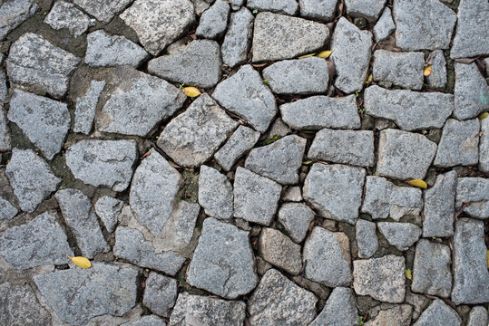 Cobble stone floor on sidewalk - texture background, focus on foreground.