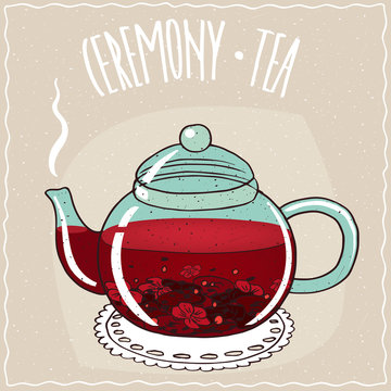 Fototapeta Transparent glass teapot with hot brewed hibiscus tea, lie on a lacy napkin. Beige background and ornate lettering Ceremony tea. Handmade cartoon style