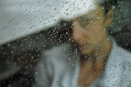 girl in the car on the glass the raindrops