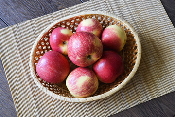 Red apples autumn harvest in a small basket