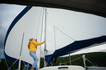 Young strong woman sailing the boat