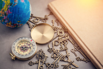 Antique Grunge compass  Skeleton Keys On grey leather table