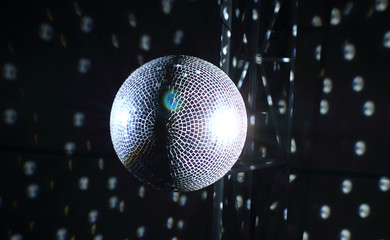 Fototapeta na wymiar Pinspots by glowing ceiling glitterball at the disco 