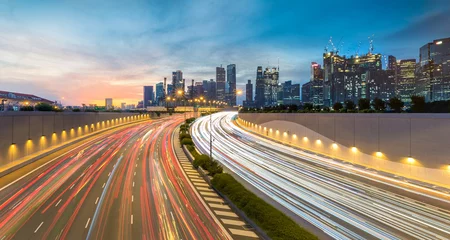 Poster Beweging van autolicht met de skyline van Singapore tijdens zonsondergang © nattapoomv