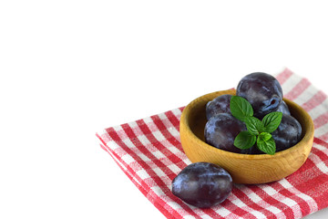 Fresh plums in the wooden bowl