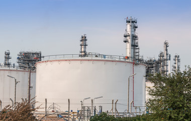Fototapeta na wymiar Big Industrial oil tanks in a refinery with treatment pond at industrial plants