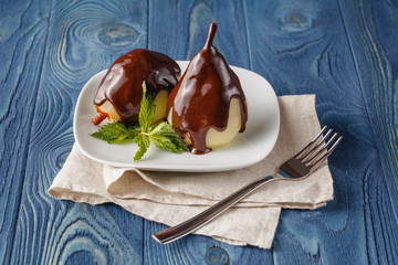 Delicious poached pears with chocolate syrup ready to serve