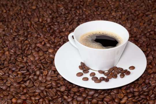 Cup of coffee over coffee beans © Vergani Fotografia