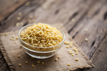 fried green gram in bowl on sackcloth and wooden background