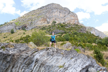 Naklejka premium girl feeling freedom in the high of a mountain with a peak behind