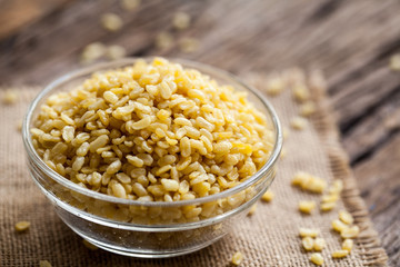 fried green gram in bowl on sackcloth and wooden background