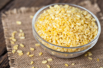 fried green gram in bowl on sackcloth and wooden background