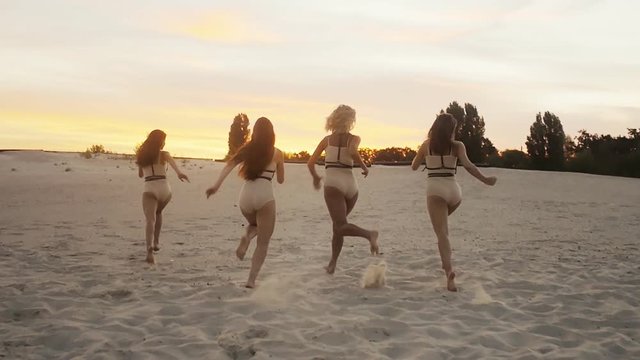 Group of Fore Teenage Girls Run at sunset in slow motion
